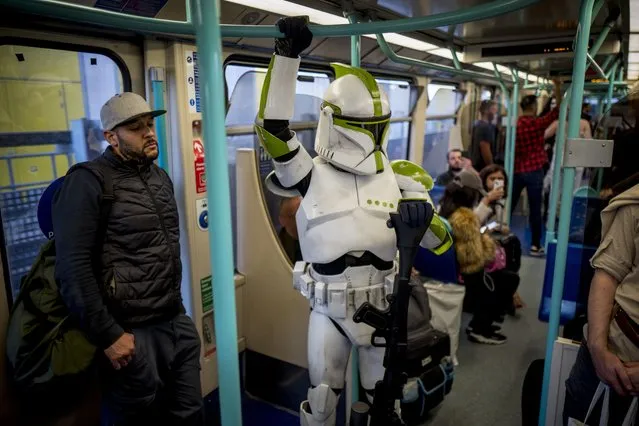 A cosplayer dressed as a Clone Trooper from Star Wars travel on a DLR train after attending MCM Comic Con in costumes at ExCeL London in London, Britain, 28 October 2022. MCM Comic Con runs from 28 to 30 October with thousands of cosplayers and film, video games and anime fans attending, as every year. (Photo by Tolga Akmen/EPA/EFE)