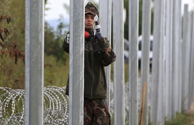Soldiers build a barbed wire fence at the Hungary-Croatia border near Sarok, Hungary, September 20, 2015. (Photo by Bernadett Szabo/Reuters)