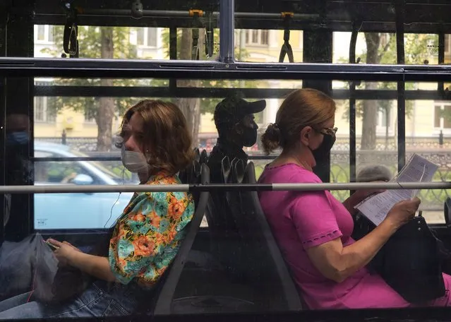 People wear protective face masks as a preventive measure against the spread of the coronavirus disease (COVID-19) while sitting in a bus in Kyiv, Ukraine on June 19, 2020. (Photo by Gleb Garanich/Reuters)
