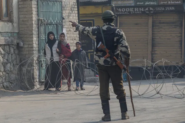 An Indian paramilitary soldier turns back Kashmiri children near a check point during restrictions in Srinagar, Indian controlled Kashmir, Friday, December 8, 2017. Hundreds of Muslim Kashmiris marched at several places in the main city of Srinagar and other parts of Indian-controlled Kashmir, against President Donald Trump's decision to recognize Jerusalem as Israel's capital. They burned U.S. and Israeli flags, while authorities imposed a curfew in old parts of Srinagar and disallowed Friday prayers at the city's main mosque for fear protests could morph into violent anti-India rallies. (Photo by Dar Yasin/AP Photo)