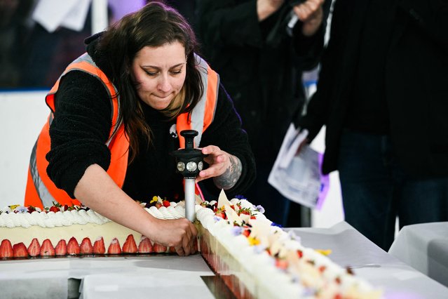 A Guinnessrecord official measures the height of the world's largest strawberry cake, 121,88m long, which traditionally must measure at least 8 cm in width and height, during a Guinness World Record event in Argenteuil, northern suburb of Paris, on April 23, 2025. Some 350 kilos of strawberries, 150 kilos of sugar, 415 kilos of creme patissiere and 4,000 eggs: on April 23, 2025, pastry chef and owner of pastry shop La Maison Heloise, Youssef El Gatou broke the record for the world's largest strawberry cake, with a cake certified to be 121.88 metres long. (Photo by Julie Sebadelha/AFP Photo)