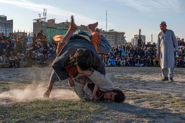 Afghan wrestlers compete in a bout of traditional mud wrestling competition during the Friday weekend at a field in Chaman-e- Huzuri ground in Kabul on October 21, 2022. (Photo by Wakil Kohsar/AFP Photo)