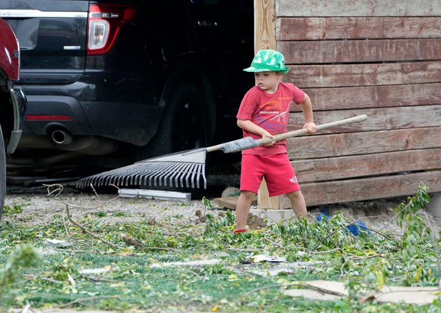 Five-year-old Preston Prescher gives his mother, Holly Prescher (not pictured), a hand with storm damage cleanup at their home along North Main Street, south of County DF in Juneau on May 16, 2025. Several tornadoes reportedly touched down in western and central Wisconsin bringing damage to the Dodge County area. (Photo by Mike De Sisti/Milwaukee Journa)