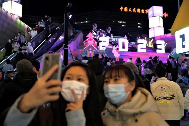 People pose for pictures with a 2023 installation at a shopping complex on New Year's Eve, amid the coronavirus disease (COVID-19) outbreak in Beijing, China on December 31, 2022. (Photo by Florence Lo/Reuters)