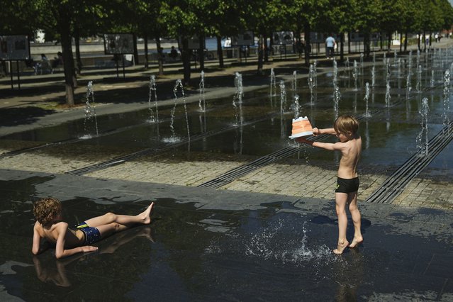 Children cool themselves by a fountain at Muzeon park in Moscow, Russia, Thursday, May 22, 2025. (Photo by Pavel Bednyakov/AP Photo)