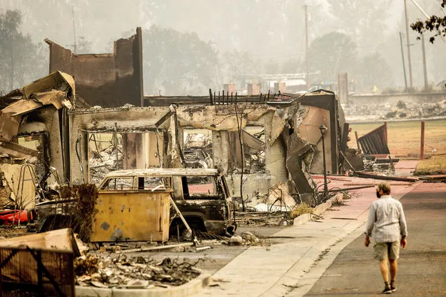 A man examines residences destroyed by the Almeda Fire at the Parkview Townhomes in Talent, Ore., on Wednesday, September 16, 2020. (Photo by Noah Berger/AP Photo)