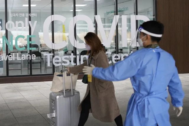 A woman arriving from China enters a COVID-19 testing center at the Incheon International Airport In Incheon, South Korea, Thursday, January 5, 2023. China suspended visas Tuesday for South Koreans to come to the country for tourism or business in apparent retaliation for COVID-19 testing requirements on Chinese travelers. (Photo by Lee Jin-man/AP Photo)