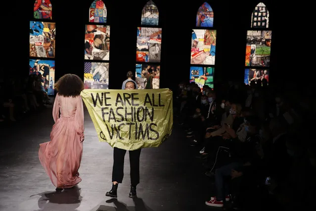 An. activist displays a banner during Dior's Spring-Summer 2021 fashion collection presented Tuesday, September 29, 2020 during the Paris fashion week. (Photo by Francois Mori/AP Photo)