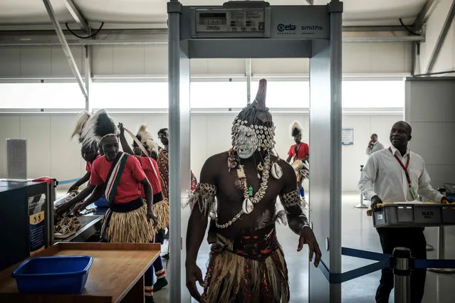 A dancer passes through a security checkpoint at the Jomo Kenyatta International airport on February 26, 2018 in Nairobi, prior to the arrival of the FIFA World Cup Trophy during its World Tour. (Photo by Yasuyoshi Chiba/AFP Photo)