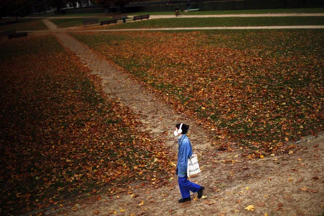 A woman, wearing a face mask to prevent the spread of the coronavirus COVID-19, walks along Cinquantenaire park in an autumn day in Brussels, Friday, October 23, 2020. Belgian Prime Minister Alexander De Croo stopped short Friday of imposing another full lockdown, as the country did in March, but introduced a series of new restrictive measures as the number of COVID-19 related hospital admissions and deaths continue to soar. (Photo by Francisco Seco/AP Photo)