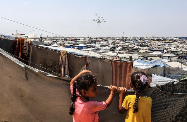 Parachutes drop humanitarian aid over the Rafah area, as residents face starvation due to the blockade imposed by Israel, in Rafah, Gaza, on August 09, 2025. (Photo by Abed Rahim Khatib/Anadolu via Getty Images)