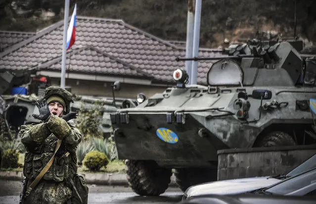 A Russian peacekeeper shouts “No pictures!” at a checkpoint outside the city of Stepanakert on November 13, 2020, during a ceasefire in the military conflict between Armenia and Azerbaijan over the breakaway region of Nagorno-Karabakh. Russian began deploying 2,000 peacekeepers to Nagorno-Karabakh on November 10 after Armenia and Azerbaijan agreed a peace deal to end weeks of fierce fighting over the disputed region. The Moscow-brokered agreement came after a string of Azerbaijani victories in its fight to retake the ethnic Armenian enclave. It sparked celebrations in Azerbaijan but fury in Armenia, where protesters took to the streets to denounce their leaders for losses in the territory, which broke from Azerbaijan's control during a war in the early 1990s. (Photo by Alexander Nemenov/AFP Photo)