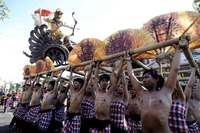 Men carry a giant “ogoh-ogoh” effigies or bewilder evil spirits during a parade to celebrate “Nyepi” or Bali's Day of Silence which falls on Hindu New Year in Denpasar, Bali, Indonesia, Tuesday, March 21, 2023. Most Balinese keep self-reflection and stay at home to observe quiet holiday. Tourists visiting the island, are asked not to leave their hotels and the airport will be closed. (Photo by Firdia Lisnawati/AP Photo)