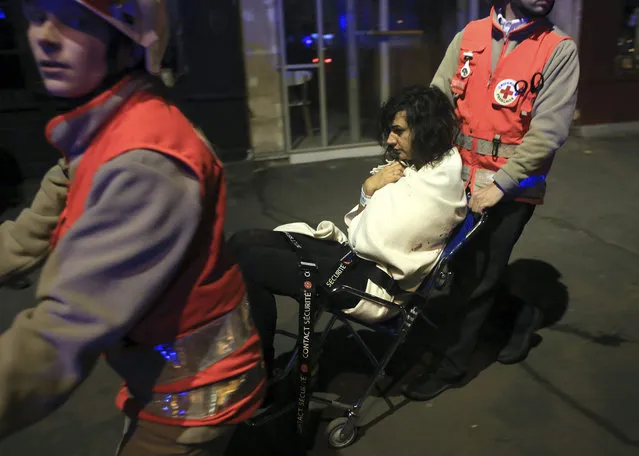 A woman is being evacuated from the Bataclan theater after a shooting in Paris, Friday November 13, 2015. (Photo by Thibault Camus/AP Photo)