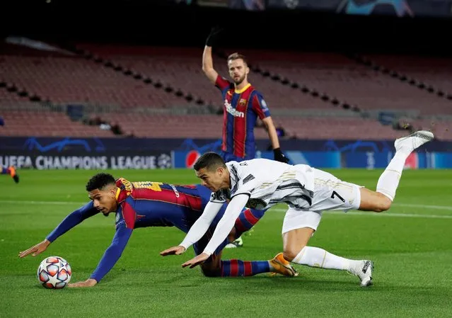 Cristiano Ronaldo of Juventus F.C. is fouled by Ronald Araujo of Barcelona which leads to a penalty awarded to Juventus during the UEFA Champions League Group G stage match between FC Barcelona and Juventus at Camp Nou on December 08, 2020 in Barcelona, Spain. Sporting stadiums around Spain remain under strict restrictions due to the Coronavirus Pandemic as Government social distancing laws prohibit fans inside venues resulting in games being played behind closed doors. (Photo by Albert Gea/Reuters)