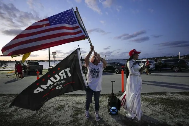 Trang Le of Orlando, right, and Maria Korynsel of North Palm Beach show their support for former President Donald Trump after the news broke that Trump has been indicted by a Manhattan grand jury, Thursday, March 30, 2023, near Trump's Mar-a-Lago estate in Palm Beach, Fla. (Photo by Rebecca Blackwell/AP Photo)