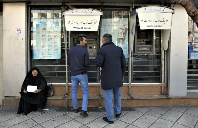 Iranians use ATM machine in a street in downtown in Tehran, Iran, 27 February 2023. According to Isna news agency, Iranian foreign minister Amir-Abdoulahian on 26 February 2023 said that Iran is close to reach a nuclear deal with US, after receiving a message from US through Iraq. Iran faces an economic crisis after its currency dropped to its lowest value against the US dollar and other foreign currencies last week, following sanctions imposed by the US and EU, amid tensions over nuclear talks, which have stopped in the wake of recent anti-government protests in the country. (Photo by Abedin Taherkenareh/EPA/EFE)