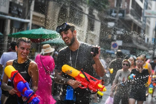 Tourists play with water as they celebrate during the Songkran holiday which marks the Thai New Year in Bangkok, Thailand on April 13, 2023. (Photo by Chalinee Thirasupa/Reuters)