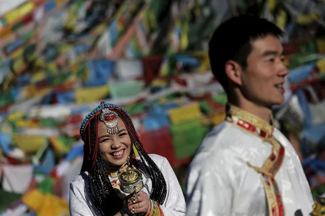 Jing Li (L) and her husband Ke Xu wear Tibetan traditional costumes as they pose for their wedding photos in front of Tibetan prayer flags at the Nianqing Tanggula mountain pass in the Tibet Autonomous Region, China November 18, 2015. (Photo by Damir Sagolj/Reuters)