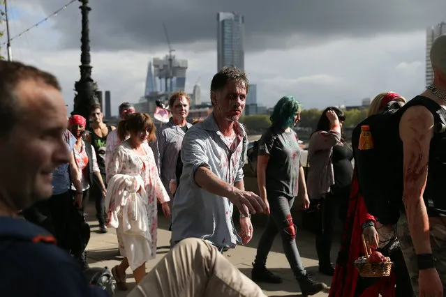 People wearing costumes participate in a “Zombie Walk” on World Zombie Day, in central London on October 8, 2016 World Zombie Day is an international annual event that grew from Pittsburgh' s first ever Zombie Walk at Monroeville Mall in 2006 – the setting for Dawn of the Dead. Now, more than 50 cities participate in the event, which in London, is used as an opportunity to raise money for chairty. (Photo by Daniel Leal- Olivas/AFP Photo)