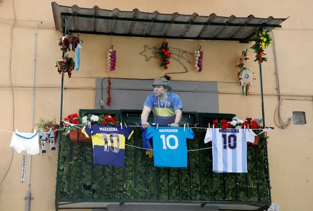 A cardboard cutout of Diego Maradona and football jerseys are pictured on a balcony ahead of Napoli potentially winning Serie A, in Naples, Italy on April 28, 2023. (Photo by Ciro De Luca/Reuters)