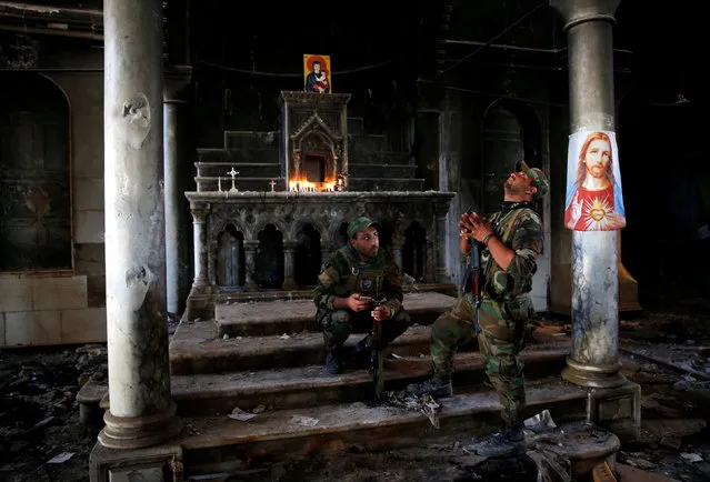 Iraqi Christian soldiers attend the first Sunday mass at the Grand Immaculate Church since it was recaptured from Islamic State in Qaraqosh, near Mosul in Iraq October 30, 2016. (Photo by Ahmed Jadallah/Reuters)