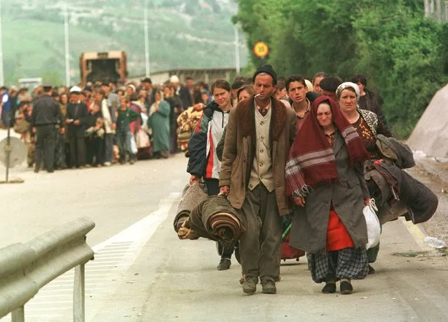 Ethnic Albanian refugees cross the Kosovo-Macedonia border at the Blace checkpoint, Tuesday, May 4, 1999. More than 675,000 ethnic Albanians have poured out of Kosovo since the NATO airstrikes began on March 24, many say they were forced out by roving bands of Serbs and are alleging mass atrocities. Thousands more refugees streamed out to Albania and Macedonia on Monday. (Photo by John McConnico/AP Photo)