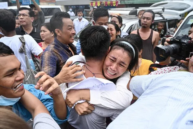 A man celebrates with a relative after being released from Insein Prison in Yangon on May 3, 2023. Myanmar's junta announced on May 3, 2023 it had pardoned 2,153 prisoners jailed under a law that criminalises encouraging dissent against the military. (Photo by AFP Photo/Stringer)