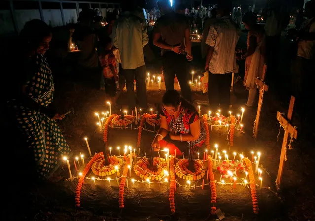 People light candles on the grave of their relatives before praying at a cemetery during the observance of All Souls Day in Agartala, India November 2, 2016. (Photo by Jayanta Dey/Reuters)