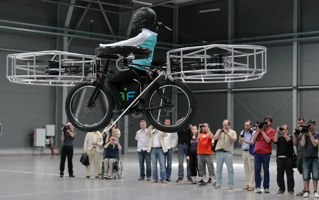 The remote-controlled Flying Bike with a test dummy is ready for its during presentation fly in Prague on Wednesday, June 12, 2013. Three Czech companies have teamed up to make a prototype of an electric bicycle that can fly. Controlled remotely, the bike carrying a figurine successfully took off Wednesday inside a large exhibition hall in Prague and landed safely after a five-minute flight. (Photo by Petr Josek/Reuters)