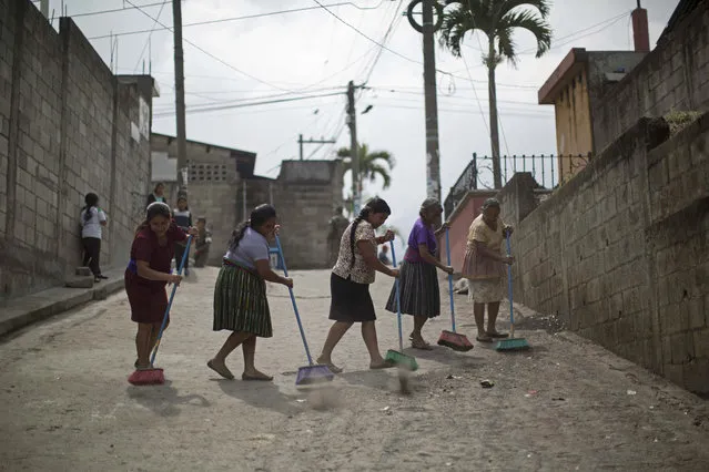 Women sweep volcanic ash and sand from the street after the eruption of the Volcan de Fuego, of Volcano of Fire, in San Juan Alotenango, Guatemala, Thursday, June 14, 2018. Guatemala's disaster agency said Wednesday, that it is resuming the search for bodies after a weeklong suspension. (Photo by Luis Soto/AP Photo)