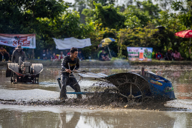 Tractor racers  compete in the Kubota sponsored iron buffalo tractor drag race on September 28, 2024 in Kamphaeng Phet, Thailand. In Thailand, iron buffalo racing has brought a modern twist to the country’s long-standing farming traditions and the traditional buffalo races held annually in Chonburi. Farmers and racers modified their two-wheeled tractors, known as iron buffaloes, to race through muddy rice paddy fields in Kamphaeng Phet province. On the first day, September 28, professional racers competed, while the second day will feature local farmers. Drivers compete with Kubota engines, battling for prizes and bragging rights. The event, sponsored by Kubota, attracted racers and audience members from around the region. The event in Kamphaeng Phet raised money for village tents and scholarships for the Nong Hua Kwai School. (Photo by Lauren DeCicca/Getty Images)