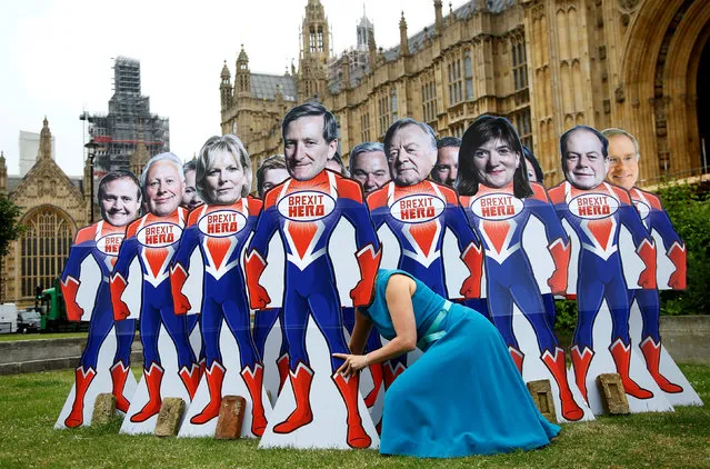 An anti-Brexit campaigner from global activism group Avaaz sets up cardboard cut-outs of Conservative Party MPs, who are known to support remaining in the EU, outside parliament in Westminster in London, Britain, June 20, 2018. (Photo by Henry Nicholls/Reuters)