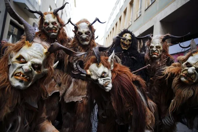 Men dressed as 'Krampuss' prepare to parade at Munich's Christmas market, December 13, 2015. (Photo by Michael Dalder/Reuters)