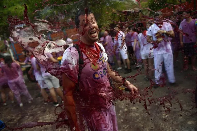 A man has wine thrown on him as he takes part in a wine battle, in the small village of Haro, northern Spain, Friday, June 29, 2018. (Photo by Alvaro Barrientos/AP Photo)