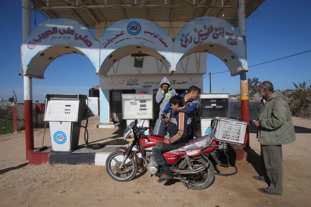 A Palestinian boy fills containers with fuel as he sits on a motorcycle at a petrol station in Khan Younis in the southern Gaza Strip, January 13, 2015. (Photo by Ibraheem Abu Mustafa/Reuters)