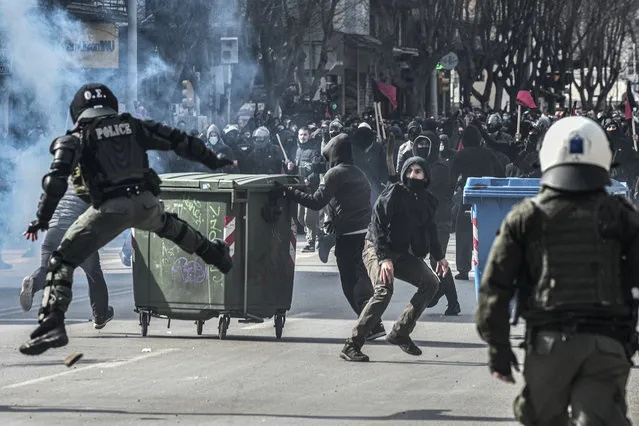 Protestors throw stones at riot police during clashes in Thessaloniki on March 11, 2021. Thousands of students take part in a demonstration against the operation of the evacuation of the Aristotle Univercity by police. (Photo by Sakis Mitrolidis/AFP Photo)
