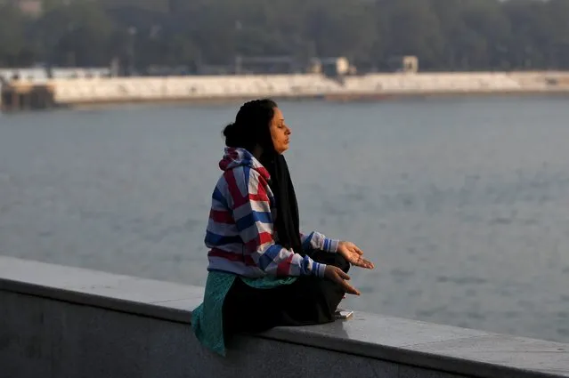 A woman performs yoga on the banks of the Kankaria Lake on a sunny winter morning in Ahmedabad, India, December 22, 2015. (Photo by Amit Dave/Reuters)