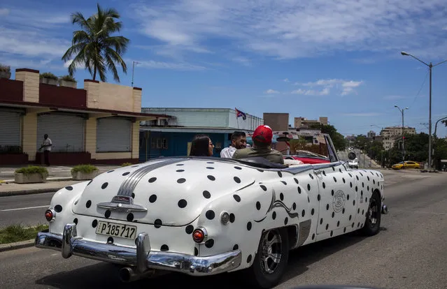 Tourists tour in a polka-dot convertible Pontiac in Havana, Cuba, Sunday, May 20, 2018. (Photo by Desmond Boylan/AP Photo)