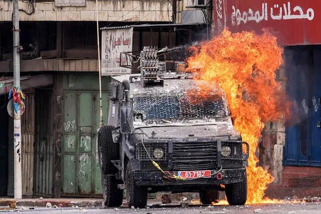 A Molotov cocktail explodes on an Israeli armoured vehicle in clashes with Palestinians during an Israeli military raid in the old city of Nablus in the occupied West Bank on July 7, 2023. (Photo by Jaafar Ashtiyeh/AFP Photo)