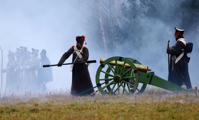 People dressed in the historic uniforms of the Imperial Russian army take part in a re-enactment of the 1812 Battle of Berezina, to mark the 204th anniversary of the battle, near the village of Bryli, Belarus, November 27, 2016. (Photo by Vasily Fedosenko/Reuters)