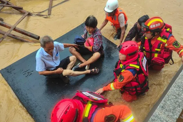 Rescuers evacuate residents in a flooded area after Typhoon Doksuri landfall in Quanzhou, in China's eastern Fujian province on July 28, 2023. (Photo by CNS/AFP Photo)