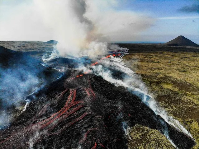 Smoke is seen billowing from flowing lava during an volcanic eruption near Litli Hrutur, south-west of Reykjavik in Iceland on July 10, 2023. (Photo by Kristinn Magnusson/AFP Photo)