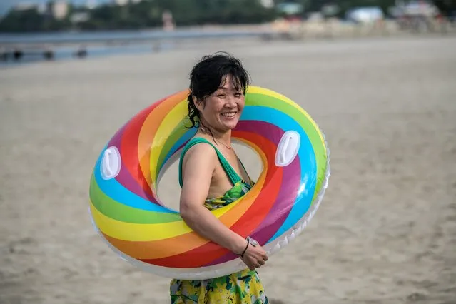 A woman carries an inflatable ring as she walks on a beach on August 22, 2018 in Wonsan, North Korea. (Photo by Carl Court/Getty Images)