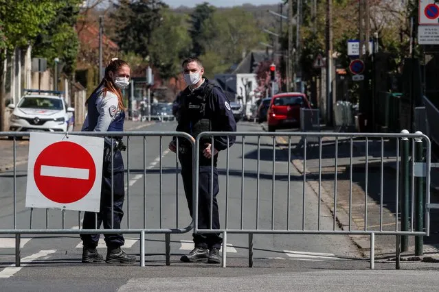 French police officers block the access next to the police station where a police official was stabbed to death Friday in Rambouillet, south west of Paris, Saturday, April 24, 2021. Anti-terrorism Investigators were questioning three people Saturday detained after the deadly knife attack a day earlier on a police official at the entry to her station in the quiet town of Rambouillet, seeking a motive, purported ties to a terrorist group and whether the attacker, killed by police, acted alone. (Photo by Michel Euler/AP Photo)