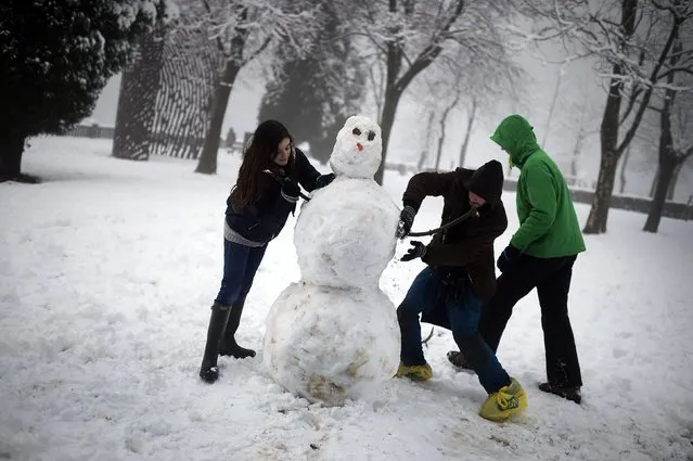 Friends make a snowman at Mt Artxanda in Bilbao following heavy snow, February 6, 2015. (Photo by Vincent West/Reuters)