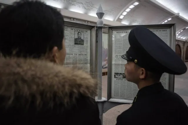A guard reads a newspaper article announcing the death of former Cuban leader Fidel Castro, at a subway station in Pyongyang on November 28, 2016. (Photo by Ed Jones/AFP Photo)