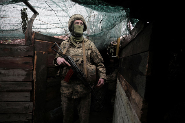 A Ukrainian serviceman stands at his position on the frontline with Russian-backed seperatists near the small city of Marinka, Donetsk region, on April 20, 2021. An emergency meeting between Russia, Ukraine and separatists was under way on April 20, 2021, in an effort to defuse soaring tensions over Russia's troop buildup along the ex-Soviet country's borders. A spokesman for the Ukrainian delegation told AFP that progress had been made on efforts to restore a ceasefire that was agreed last July but upended by a recent spate of clashes between Ukrainian troops and Moscow-backed separatists in eastern Ukraine. (Photo by Aleksey Filippov/AFP Photo)
