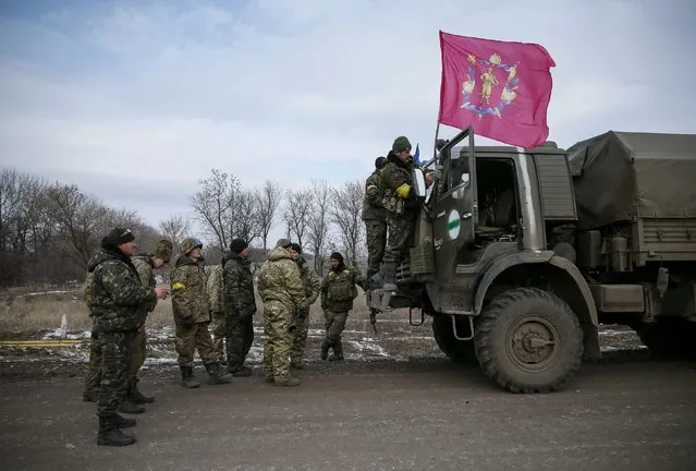 Ukrainian servicemen who fought in Debaltseve hoist a flag of their unit and gather near Artemivsk February 19, 2015. (Photo by Gleb Garanich/Reuters)