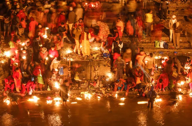 Nepalese Hindu devotees offer oil lamps in the Bagmati River as they observe the festival of Bala Chaturdashi in the early morning hours at the Pashupati Temple in Kathmandu, Nepal, 28 November 2016. Seven kinds of seeds – paddy, barley, sesame, wheat, gram, maize and finger millet – are sown around the temple premises in the name of loved ones departed during the last three years, in the belief that the departed souls will receive salvation. (Photo by Narendra Shrestha)